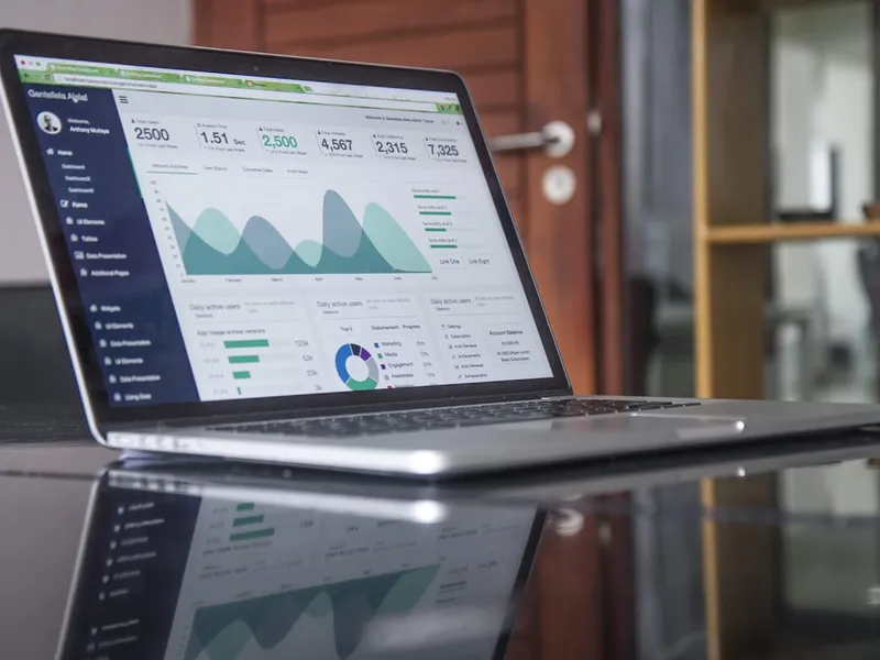 Portátil abierto sobre una mesa con un panel de métricas de usuarios en pantalla