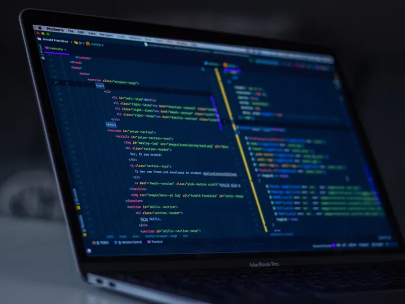 Portátil mostrando un editor de código con resaltado de sintaxis sobre fondo oscuro
